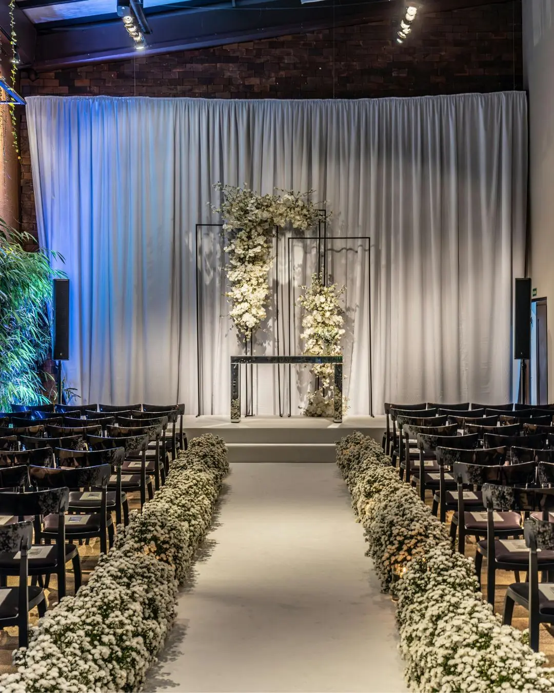 Elegant wedding stage decoration with floral arrangements and soft lighting.
